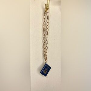 Gold chain bracelet with miniature passport charm